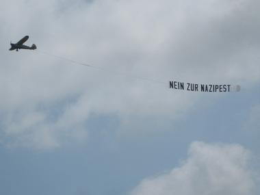 Flugzeug mit Banner Nein zur Nazipest